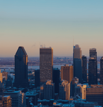 Image de la ville de Montréal mettant en valeur la Place Ville-Marie au coucher du soleil.